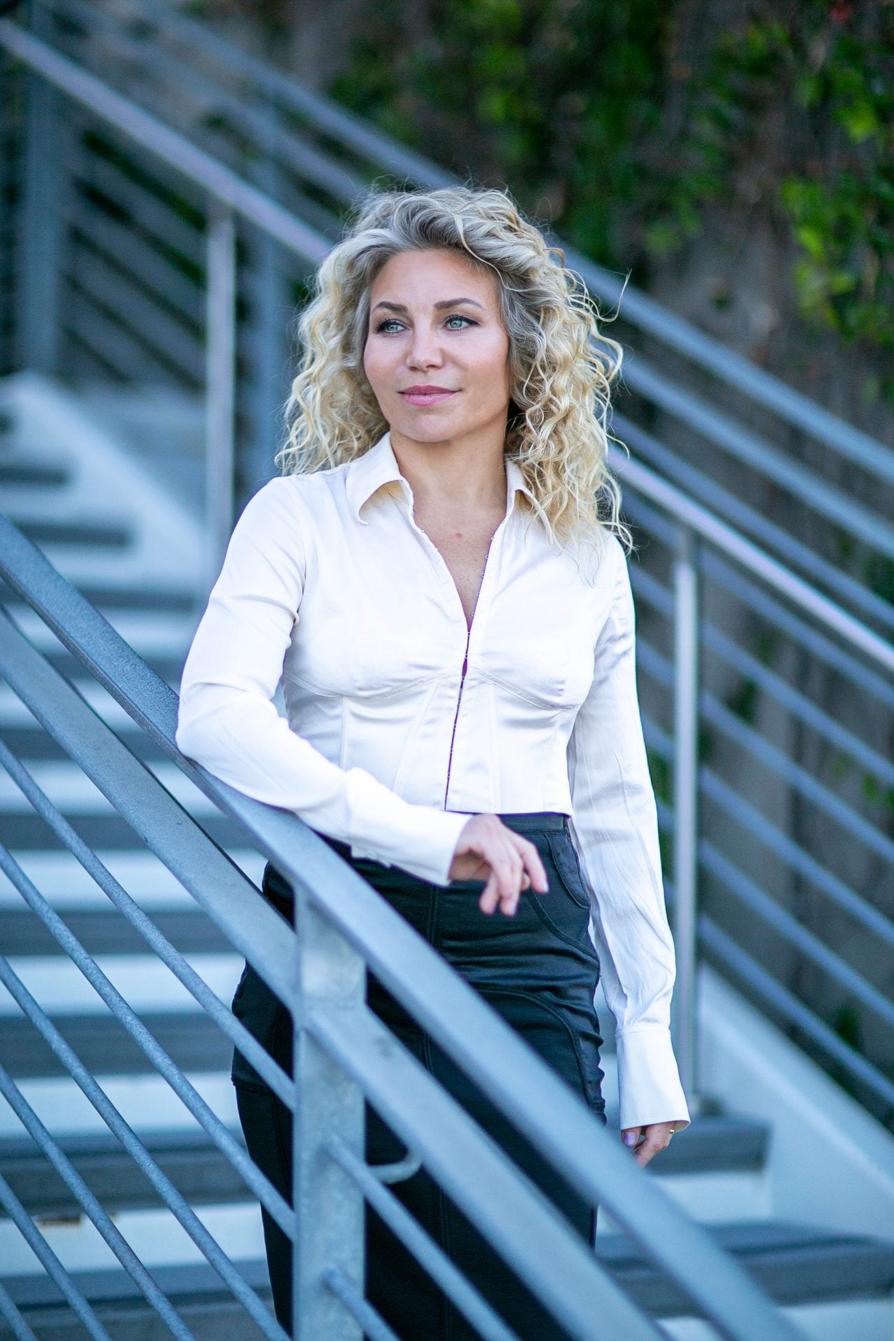 Dr. Marta Rudat standing beside an outdoor staircase in Tustin, California.