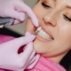 Dentist comparing a porcelain veneer shade to a patient's front teeth