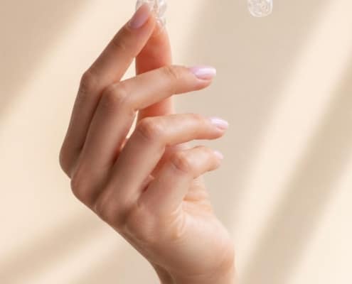 Clear Invisalign aligner held in a woman's hand