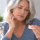Woman examining a loose denture that no longer fits comfortably